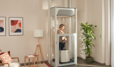 Mujer de mediana edad en su ascensor doméstico Stannah Uplifts S2.